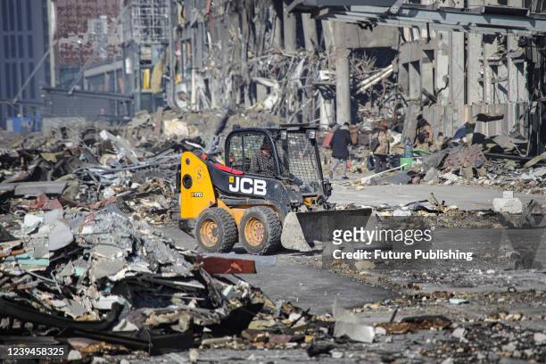 Driver operates a bucket loader to remove rubble from the premises of a shopping mall ruined as a result of a missile strike carried out by the...