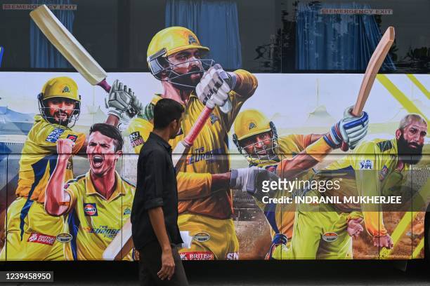 Pedestrian walks past the bus of Indian Premier League's Chennai Super Kings in Mumbai on March 24, 2022.
