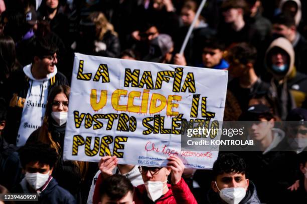 Demonstrators hold a hold a placard writing "Mafia kills, your silence too" during the 27th march organized by Libera Association in memory of...