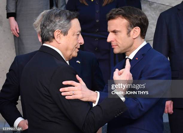 Italy's Prime Minister Mario Draghi shakes hands with France's President Emmanuel Macron at NATO Headquarters in Brussels on March 24, 2022.