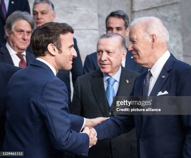 March 2022, Belgium, Brüssel: Emmanuel Macron , President of France greets Joe Biden, President of the United States, as leaders pose for a family...