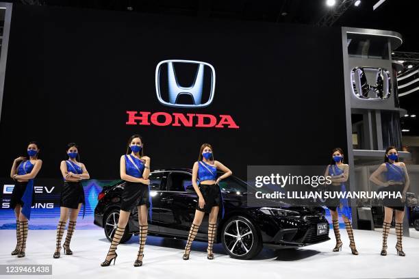 Models promote the new Honda Civic car displayed at the Bangkok International Motor Show in Bangkok on March 24, 2022.