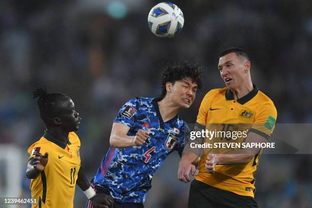 Japan's midfielder Kou Itakura , Australia's midfielder Awer Mabil and forward Mitchell Duke tussle for the ball during the Qatar World Cup 2022...