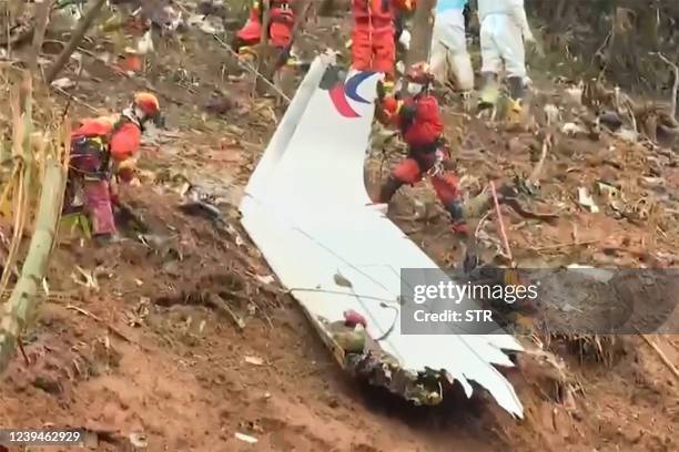 This screengrab taken on March 24, 2022 from video by state broadcaster China Central Television via AFPTV shows rescue teams with a piece of the...