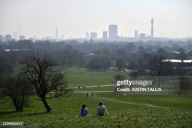 People enjoy a day out at Primrose Hill as a high air pollution warning was issued for London on March 24, 2022.