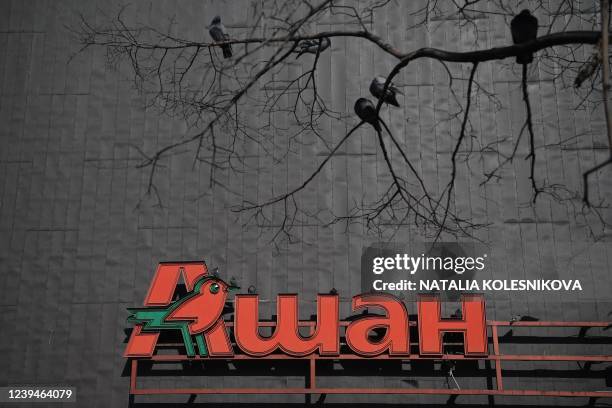 The logo of French retailer Auchan is pictured on a shopping centre in Moscow on March 24, 2022. - Ukrainian President Volodymyr Zelensky used a...