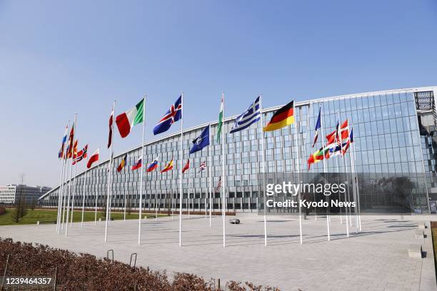 Photo taken March 24 shows the flags of the North Atlantic Treaty Organization and its member nations at NATO headquarters in Brussels.