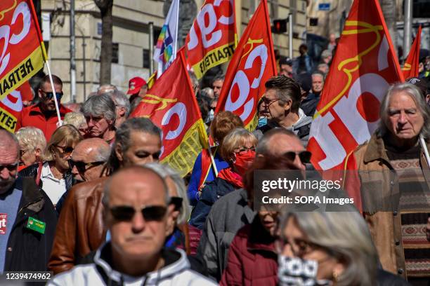 Protesters march with flags during the demonstration. Retirees have held protests in some 20 towns across France to demand higher pensions and better...