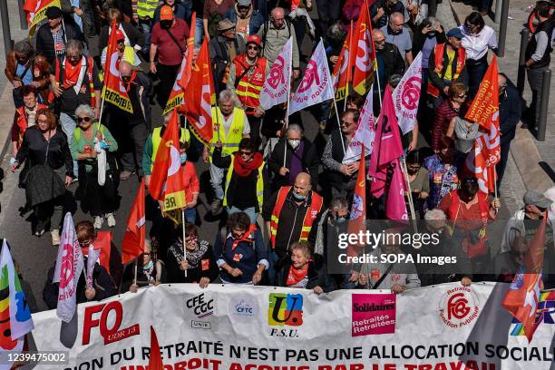 Protesters hold a banner and flags during the demonstration. Retirees have held protests in some 20 towns across France to demand higher pensions and...