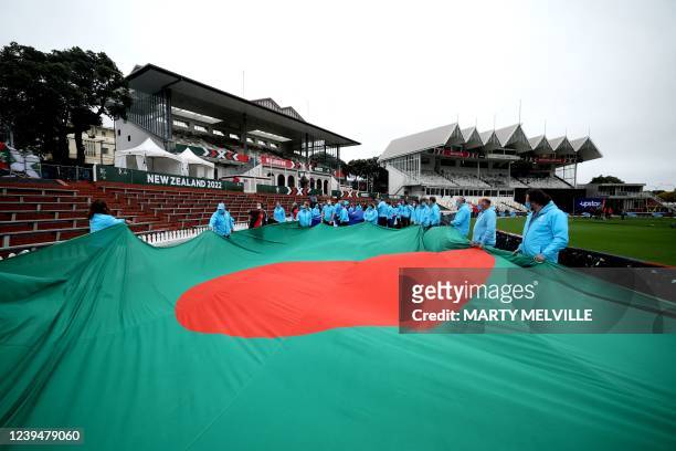 Volunteers carry a Bangladesh national flag for a ceremony before the start of the Women's Cricket World Cup match between the Australia and...