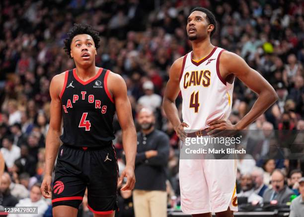 Scottie Barnes of the Toronto Raptors and Evan Mobley of the Cleveland Cavaliers look on in a break during the first half of their basketball game at...