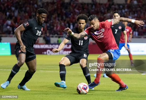 Costa Rica's Ronald Matarrita vies for the ball with Canada´s Jonathan David and Tajon Buchanan during their FIFA World Cup Qatar 2022 Concacaf...