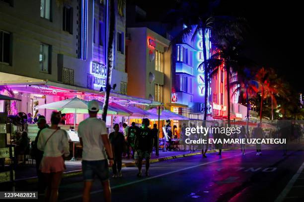 People walk on Ocean Drive during Spring Break in Miami Beach, Florida, on March 24, 2022. - The US city of Miami Beach has declared a state of...
