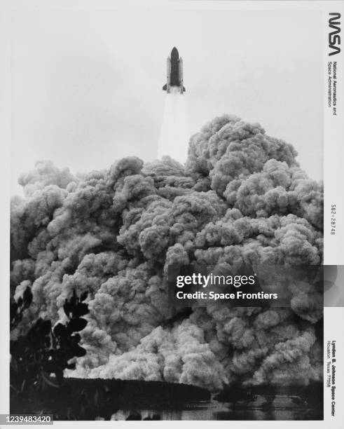 The Space Shuttle Columbia, its two white solid rocket boosters and its orange external fuel tank soaring toward Earth orbit launching NASA's Mission...