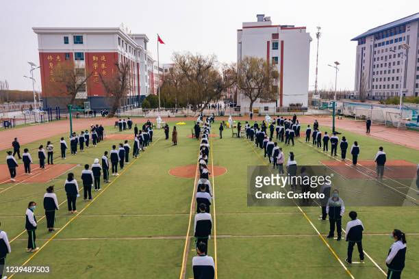 Aerial photo taken on March 24, 2022 shows middle school students queuing for nucleic acid testing in Jiuquan city, Gansu Province, China.