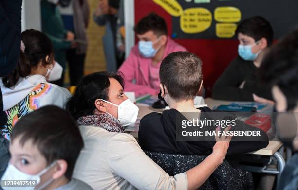 Teacher talks to a pupil from Ukraine during an international class at the Max-Ernst comprehensive school in Cologne, western Germany on March 25,...