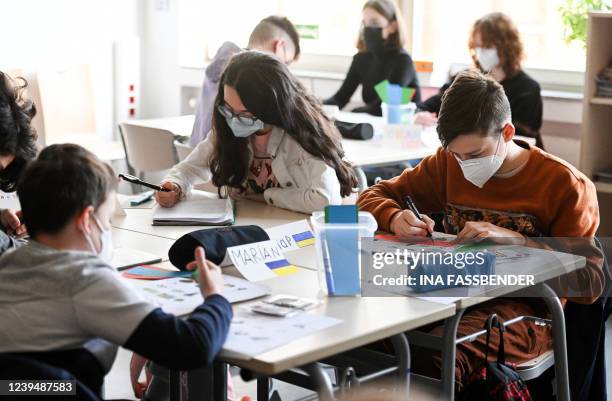 Pupils, among others from Ukraine, sit together during an international school class at the Max-Ernst comprehensive school in Cologne, western...