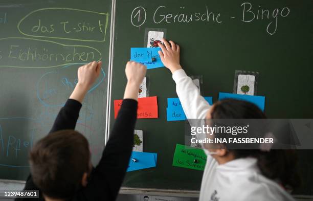 Pupil from Ukraine and a girl react in front of a school blackboard during an international school class at the Max-Ernst comprehensive school in...