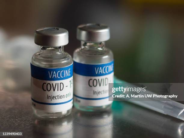 ready-to-inject vials of covid-19 vaccine - administered stock pictures, royalty-free photos & images