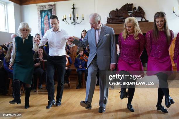 Britain's Camilla, Duchess of Cornwall and Britain's Prince Charles, Prince of Wales are shown the steps of a traditional Irish dance at the Bru Boru...