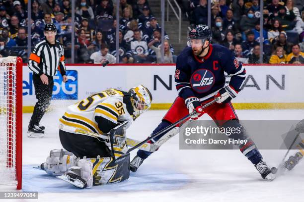 Blake Wheeler of the Winnipeg Jets keeps an eye on the flying puck over goaltender Linus Ullmark of the Boston Bruins during second period action at...