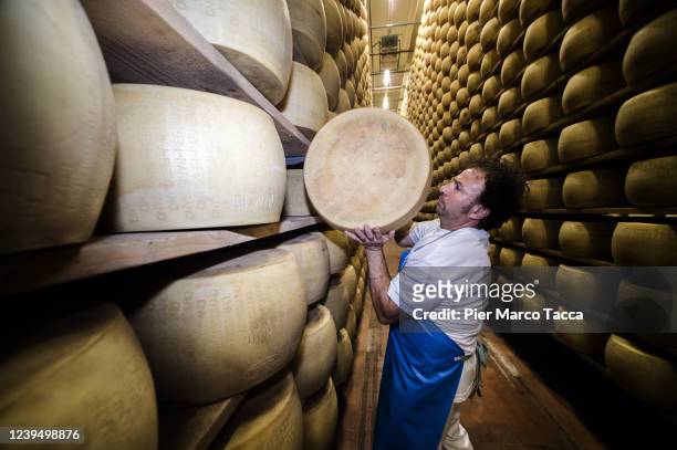 Dairyman, Antonio Landi moves a wheel of Parmigiano Reggiano in the storage warehouse of Latteria La Grande on May 30, 2020 in Castelnovo, Italy....