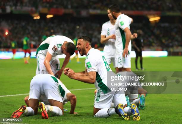 Algeria's Islam Slimani bows on the pitch as he celebrates a goal with teammates looks on during the FIFA World Cup Qatar 2022 qualifying third round...