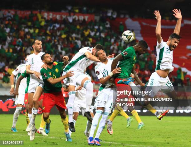 Players jump for control of the ball during the FIFA World Cup Qatar 2022 qualifying third round football match between Algeria and Cameroon at the...