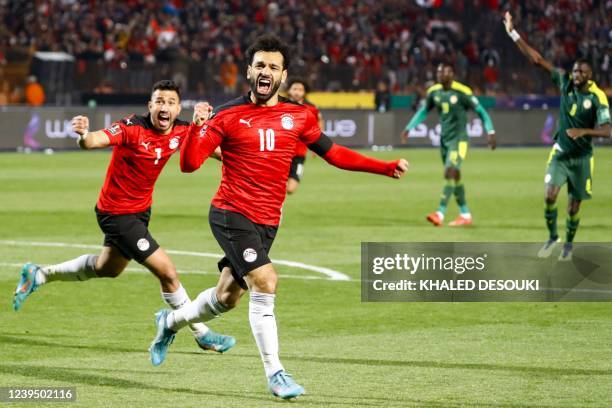 Egypt's forward Mohamed Salah and Egypt's midfielder Mahmoud 'Trezeguet' Hassan celebrate after a goal during the 2022 Qatar World Cup African...