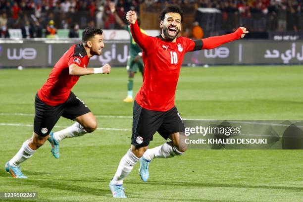 Egypt's forward Mohamed Salah and Egypt's midfielder Mahmoud 'Trezeguet' Hassan celebrate after a goal during the 2022 Qatar World Cup African...