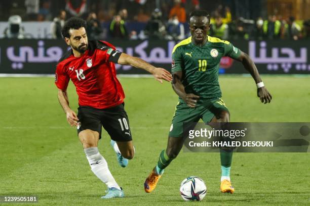 Egypt's forward Mohamed Salah vies for the ball against Senegal's forward Sadio Mane during the 2022 Qatar World Cup African Qualifiers football...