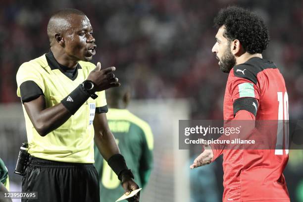 March 2022, Egypt, Cairo: Egypt's Mohamed Salah speaks with referee Jean-Jacques Ndala during the 2022 FIFA World Cup qualification third round 1st...