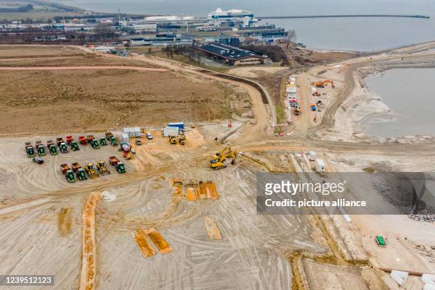 March 2022, Schleswig-Holstein, Fehmarn: Construction vehicles stand on the Baltic Sea coast during the construction of the Baltic Sea tunnel between...