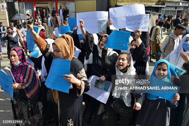 Afghan women and girls take part in a protest in front of the Ministry of Education in Kabul on March 26 demanding that high schools be reopened for...