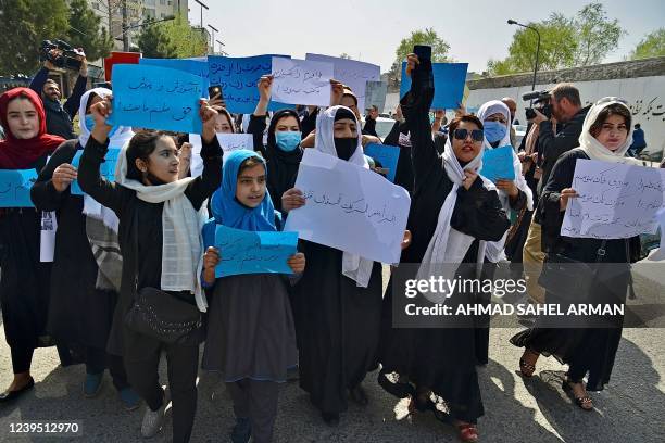 Afghan women and girls take part in a protest in front of the Ministry of Education in Kabul on March 26 demanding that high schools be reopened for...