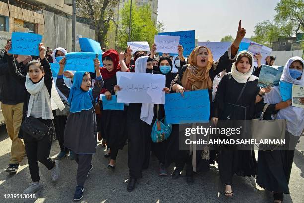 Afghan women and girls take part in a protest in front of the Ministry of Education in Kabul on March 26 demanding that high schools be reopened for...
