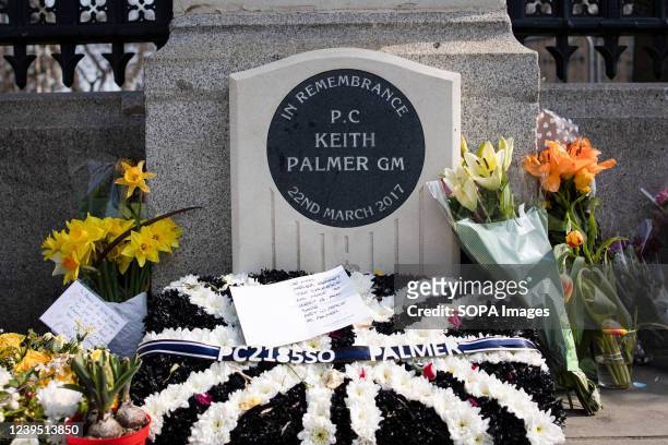 Flowers are seen laid in tribute to the policeman, Keith Palmer, who died in the terrorist attack outside the House of Parliament in 2017. Different...