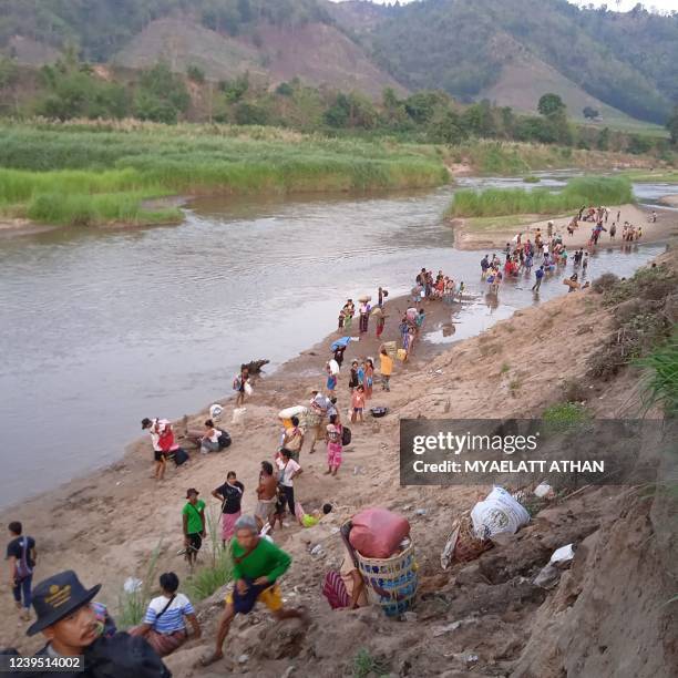Displaced people from Myanmar walk along the Moei river on the border with Thailand after fleeing their villages following clashes between the...