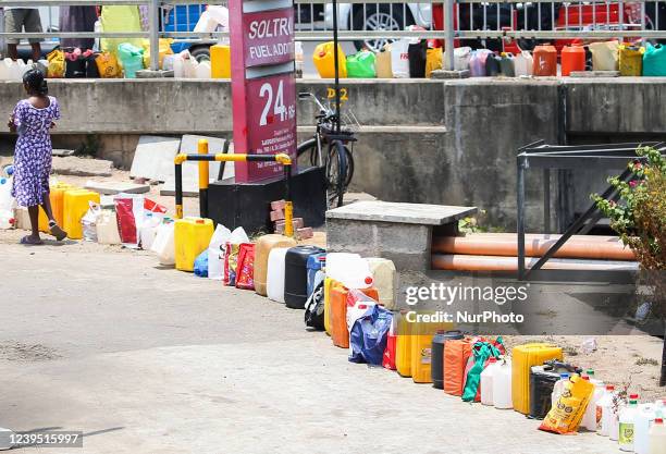 Empty cans line up at a fuel station in Colombo on March 26, 2022. The island has been severely hit by the lack of foreign exchange, resulting in...