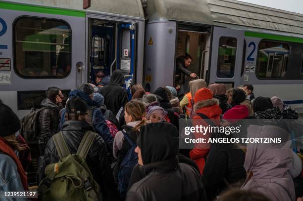 Ukrainian evacuees board to a train en route to Warsaw at the rail station in Przemysl, near the Polish-Ukrainian border, on March 26 following...