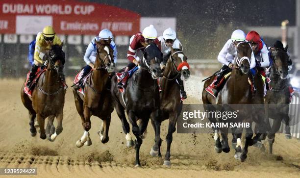 Jockeys compete in the Dubai World Cup horse racing event at the Meydan racecourse in the Gulf emirate, on March 26, 2022.
