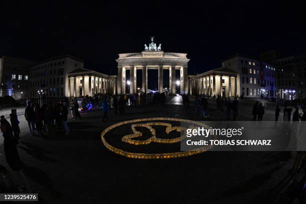 Dove of peace formed from candles in paper bags is pictured before the illumination of Berlin's Brandenburg Gate turn off on the occasion of the...