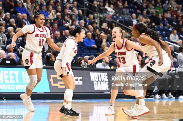 Jake Brown-Turner, Raina Perez, Elissa Cunene and Kayla Jones of the NC State Wolfpack celebrate their win over the Notre Dame Fighting Irish during...