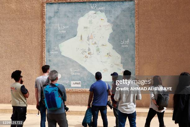 Foreign tourists visit the ancient city of Babylon, some 100 km south of the Iraqi capital Baghdad, on March 7, 2022. - Between the 2003 US invasion,...