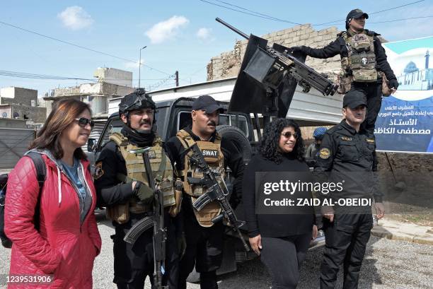 Tourists pose for a picture with Iraqi security forces in the northern Iraqi city of Mosul, on March 12, 2022. - Between the 2003 US invasion, the...