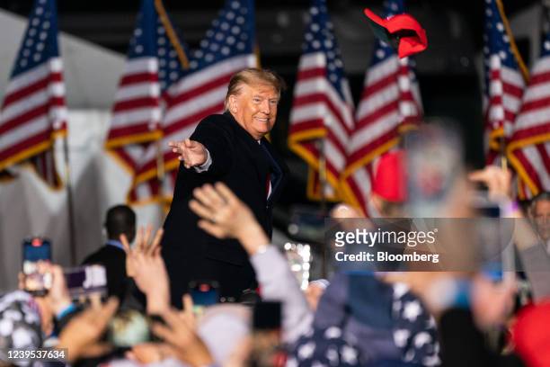 Former U.S. President Donald Trump tosses a hat into the crowd at a 'Save America' rally in Commerce, Georgia, U.S., on Saturday, March 26, 2022....