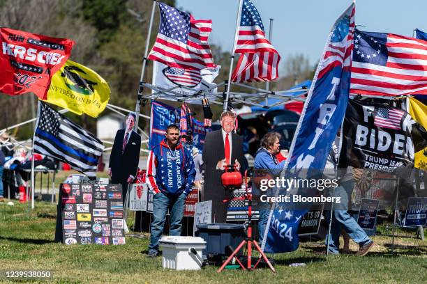 Man stands next to a cardboard cutout of former President Donald Trump at a vendor's booth outside a Georgia state Republican campaign event...