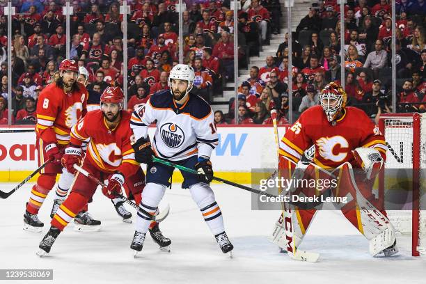 Oliver Kylington and Jacob Markstrom of the Calgary Flames defend net against Derick Brassard of the Edmonton Oilers during the second period an NHL...