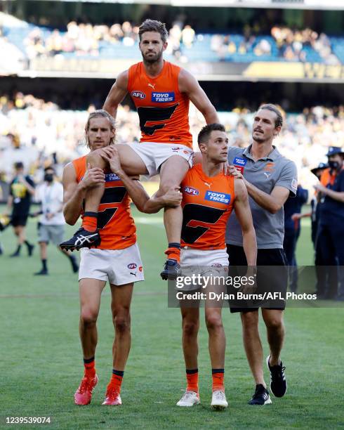 Callan Ward of the Giants is chaired off the ground by Nick Haynes, Josh Kelly and Phil Davis of the Giants during the 2022 AFL Round 02 match...