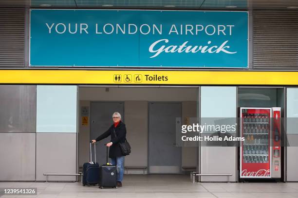 Traveller stands with her luggage at Gatwick Airport on March 27, 2022 in London, England. Gatwick's South terminal closed in June 2020 to reduce...
